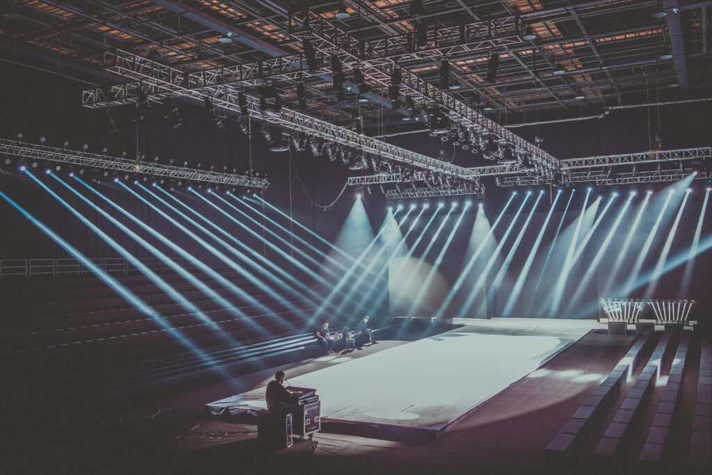 pexels-photo-2177813-2177813 An expansive indoor stage with dramatic lighting setup, ready for a performance or event.